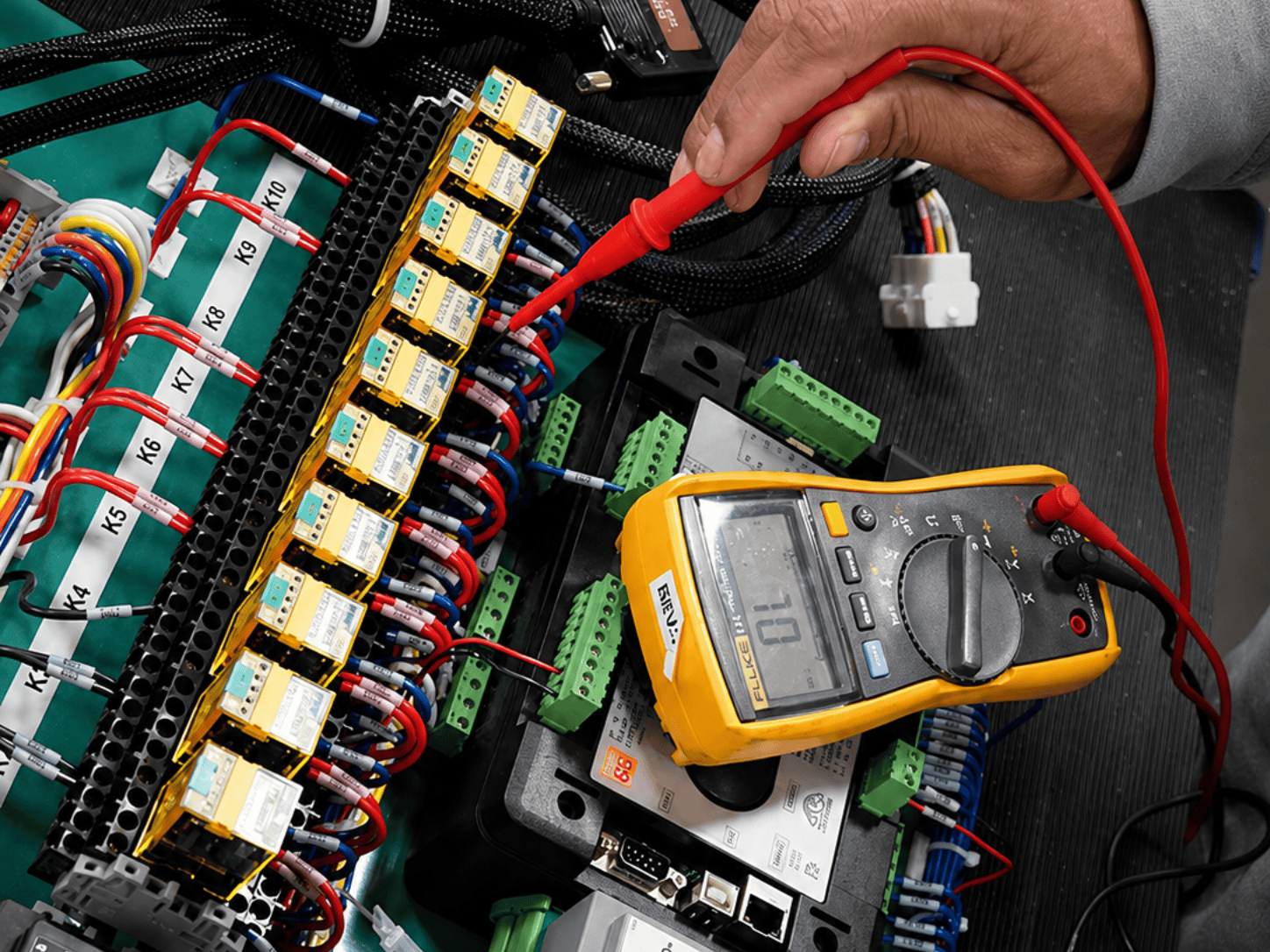 Control panel being tested with a voltage tester.